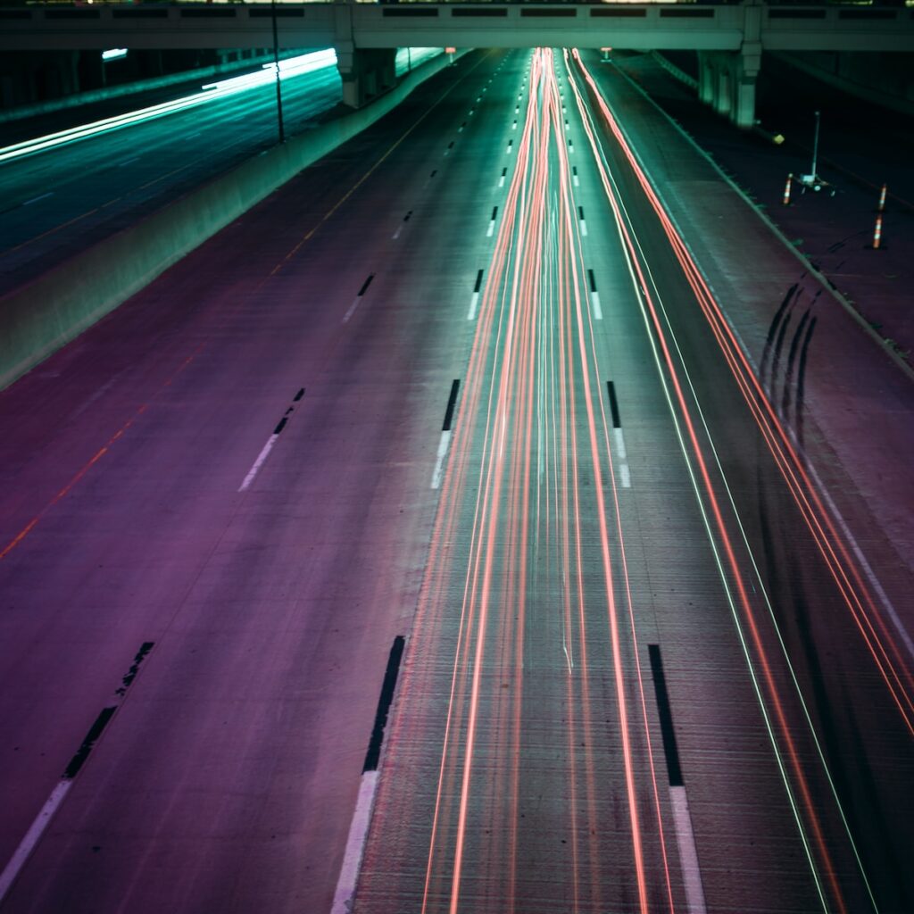 time lapse photography of moving vehicles on road